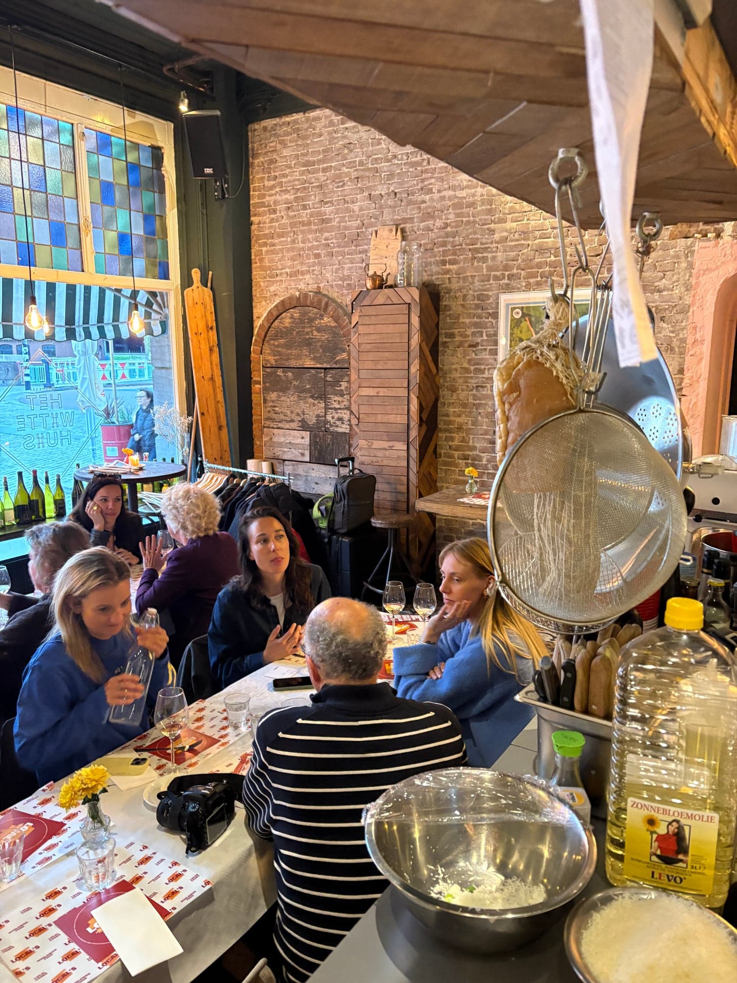Gasten aan tafel tegen de bakstenen muur