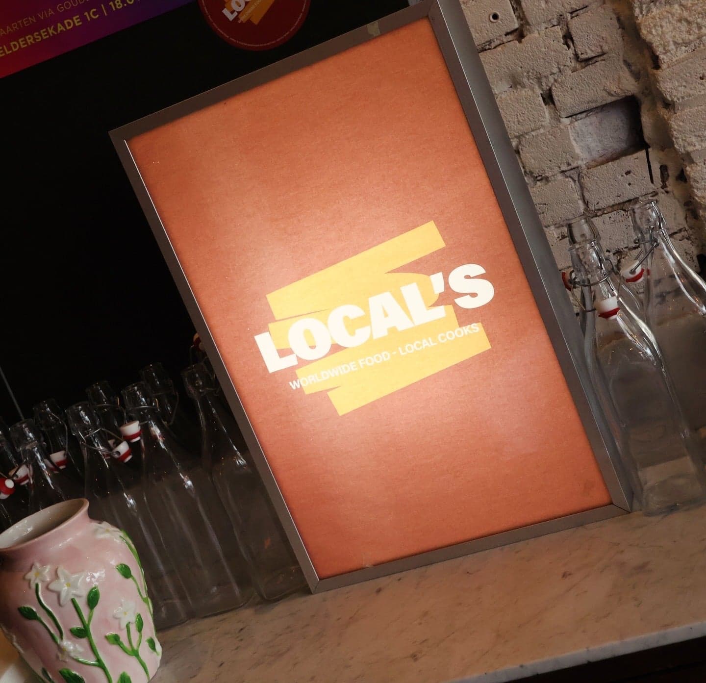 Oranje Local's-lichtbak tussen beugelflessen